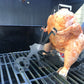 Cooking chicken on bbq with a beer can chicken stand